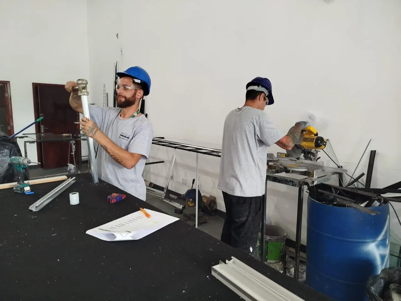 Equipe do Grupo Magnani cortando perfis de alumínio na oficina própria