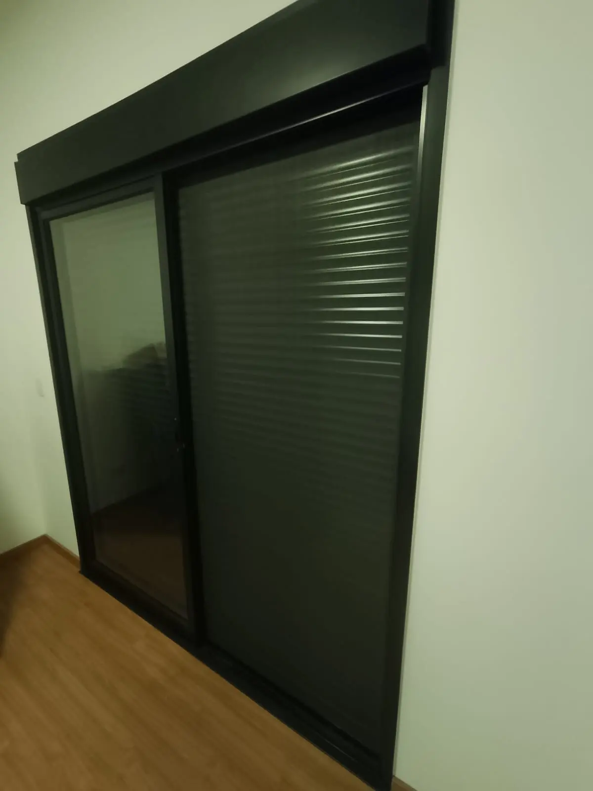 Janela de alumínio com persiana integrada, instalada em quarto